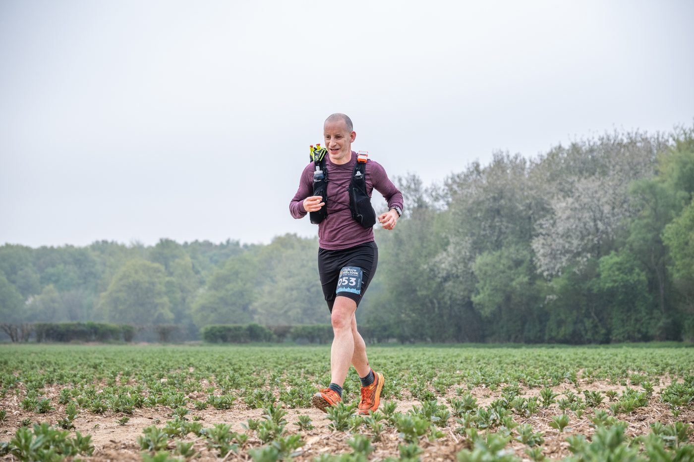 Rob running through a field at the Chiltern Hills 100k